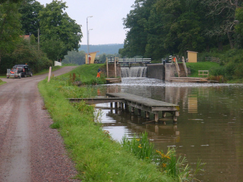 Maintenance workers trimming grass around a Lock.